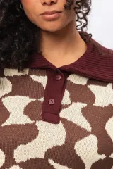 Buzo de tejido de punto con diseño estampado geométrico retro, cuello tipo polo con cierre frontal de botones y mangas largas con puños acanalados en color bordó.