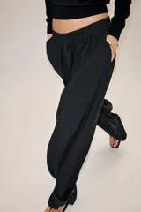 Pantalón fluido de tiro medio, confeccionado en mezcla de modal, con cintura elástica ajustable mediante cordones. Presenta pinzas en el delantero, bolsillos laterales ocultos y bajo ajustable con trabilla y botón a presión.