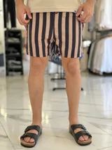 Short de baño con diseño de rayas verticales en color azul marino y blanco, con cintura elástica y cordón ajustable.