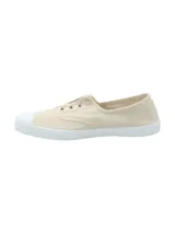 Zapatillas bajas de lona color beige, con puntera de goma blanca y ajuste sin cordones.