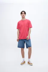 Remera celeste de algodón con bolsillo en el pecho, teñida en prenda. Tiene una etiqueta en el bolsillo y un estampado en la espalda.
