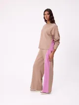 Sweater de corte oversize y estilo cropped, color gris oscuro, con cuello redondo y detalle de costura en forma de X en el pecho. Presenta un pequeño logo bordado en el ruedo inferior.