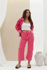 Pantalón de denim de tiro medio con diseño de rayas verticales en tonos rojo y rosado, de corte recto y largo midi.