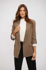 Blazer color marrón topo, de corte relajado y manga larga con detalle de tira ajustable para remangar. Tiene solapas anchas y bolsillos frontales.