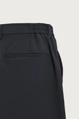 Pantalón regular fit color negro de corte recto, con cintura elástica en los laterales, trabillas, bolsillos frontales y cierre con botón y cremallera.