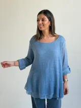 Sweater de punto color azul jean, con cuello redondo, mangas largas con vuelta y diseño amplio de corte evasé.