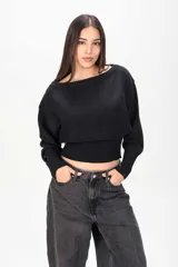 Sweater negro de punto con diseño holgado, escote bote y cintura ajustada con elástico ancho.