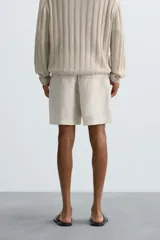 Bermuda relaxed fit confeccionada en tejido ligero de cáñamo. Presenta cintura elástica ajustable con cordón interior, bolsillos laterales y un bolsillo trasero de plastrón con solapa.