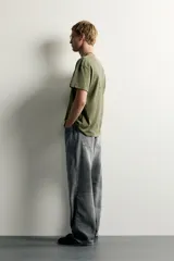 Jeans de denim de algodón en color azul con efecto desgastado, tiro medio y corte recto de ajuste holgado (loose fit). Cuenta con diseño clásico de cinco bolsillos y cierre frontal con cremallera y botón.