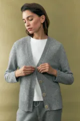 Cárdigan gris melange con cuello en V y cierre frontal con botones.