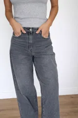 Jeans mom fit color gris, de tiro alto, con bolsillos delanteros y traseros. Confeccionado en algodón, lyocell y elastano.
