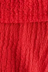 Top rojo con textura, corte ajustado y hombros descubiertos.