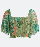 Blusa cropped de tul con estampado de bananas, escote cuadrado, mangas cortas amplias, detalle de látex en el cuerpo y volantes en el bajo.