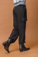 Pantalón cargo de tiro medio con bolsillos laterales tipo parche y puños elásticos en los tobillos.