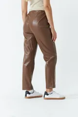 Pantalón de cuero sintético marrón, de tiro alto y corte recto, con pinzas y tablas en la parte delantera.