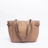 Cartera tipo tote de cuero sintético con textura granulada, color camel. Presenta doble asa de hombro y correas laterales ajustables con hebillas metálicas.