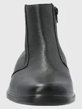 Botín de cuero negro, estilo chelsea con cierre lateral. Presenta un acabado de cuero granulado y suela de poliuretano negra.