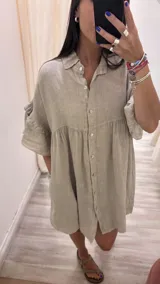 Vestido camisero blanco de lino italiano, con cuello camisero, cierre frontal con botones, mangas cortas con doble volado y bolsillos laterales.