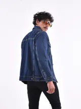 Campera de jean azul de hombre, con cuello camisero, cierre frontal de botones y bolsillos a la altura del pecho.