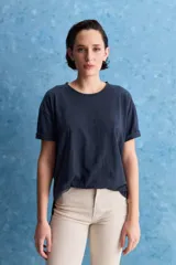 Remera negra de calce amplio, confeccionada en algodón liviano, con cuello redondo, mangas cortas y hombros levemente caídos.
