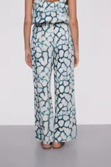 Pantalón largo de viscosa con estampado abstracto en tonos azules y blancos, cintura alta con cordón ajustable y corte ancho.