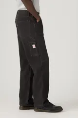 Pantalón tipo carpenter de corte holgado y recto, con diseño de cinco bolsillos y costuras reforzadas características del estilo utilitario.