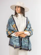 Pashmina de diseño artístico con estampado abstracto en tonos azules, celestes y amarillos. Presenta bordes con ribete oscuro y terminaciones con flecos cortos.