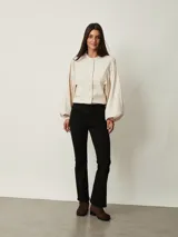 Pantalón de jean negro de corte flare, con tiro medio y bolsillos delanteros y traseros.