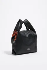 Bolso de mano mediano Bimba y Lola modelo Paper, confeccionado en piel vacuna negra, de estructura blanda y forma trapezoidal. Posee asas de mano y un cordón decorativo naranja y blanco en uno de los laterales. Lleva el logo metálico de la marca en la parte inferior frontal.
