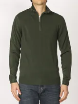 Sweater verde oliva de tejido acrílico con textura similar al cashmere, corte clásico, cuello alto con cierre metálico y tirador de cuerina ecológica.