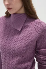 Sweater de punto con diseño de ochos, color camel, con cuello alto y mangas largas.
