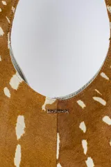 Cartera acolchada negra de silueta ovalada con asa circular integrada y diseño matelassé en rombos.