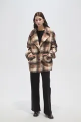 Tapado de lana con diseño a cuadros en tonos marrones y beige, de corte holgado, con cuello de solapa y cierre frontal con botones.
