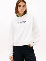 Buzo de felpa blanco de Tommy Hilfiger con cuello redondo, manga larga y calce regular. Cuenta con el logotipo de la marca bordado en tipografía script en el pecho y botones dorados decorativos en el hombro.