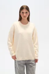 Sweater negro holgado con cuello a la base, manga larga y detalles de mostacillas formando un patrón abstracto.