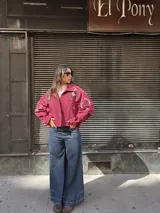 Campera tipo bomber color bordó, confeccionada en gamuza, con cierre frontal y bordados decorativos en el pecho y las mangas. Presenta un diseño holgado con puños y cuello clásico.