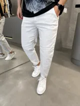 Jean slouchy de color beige, con corte holgado en las piernas y botamangas ligeramente ajustadas o dobladas.