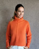 Sweater color crudo de cuello alto con mangas largas y corte holgado.