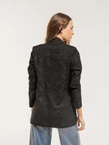 Blazer negro con bordado floral, de corte recto y largo a la cadera.