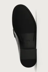 Mocasín de vestir color marrón oscuro, fabricado en cuero, con detalle de antifaz en el empeine y suela a tono con ligero tacón.