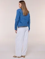 Campera de jean blanca de corte clásico, con cuello solapa, cierre frontal de botones metálicos y bolsillos aplicados con solapa en el pecho.
