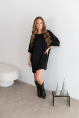 Remerón de encaje color negro, de diseño oversize con cuello redondo y mangas cortas de hombros caídos.