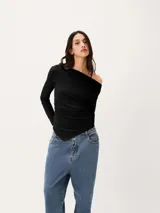 Blusa negra de manga larga con diseño asimétrico en el escote, dejando un hombro al descubierto. Presenta un corte ajustado con detalle de frunces laterales que crean un efecto drapeado en el torso.