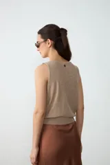 Chaleco tejido de punto sin mangas, color beige, con escote en V profundo y dobladillo acanalado.