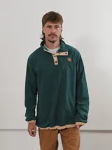 Buzo de pana color beige con cuello polo abotonado y bolsillo en el pecho.