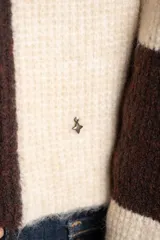 Sweater de tejido de punto grueso, con diseño de rayas verticales anchas en tonos marrón oscuro y negro. Presenta cuello redondo y mangas largas.