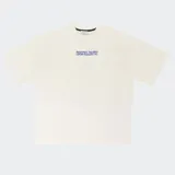 Remera de algodón color beige con corte oversize, hombros caídos y silueta cuadrada. Presenta un estampado gráfico en color azul en el centro del pecho.