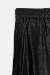 Pantalón de tiro alto color verde militar, confeccionado en tejido satinado con acabado brillante. Presenta cintura elástica fruncida, bolsillos laterales ocultos en las costuras y perneras de corte ancho.