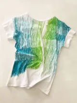 Remera blanca de algodón con estampado abstracto en tonos ocre, verde y gris. De corte holgado y mangas cortas.