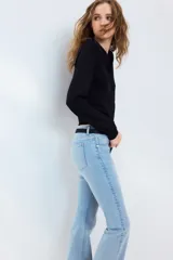 Jean de denim celeste claro con efecto desteñido, tiro bajo, corte ajustado en la parte superior y piernas acampanadas.